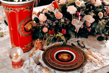 Güzel bir tabak ve mükemmel renkte çiçekler lüks bir masada duruyor.