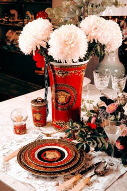 Güzel bir tabak ve mükemmel renkte çiçekler lüks bir masada duruyor.