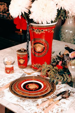 Güzel bir tabak ve mükemmel renkte çiçekler lüks bir masada duruyor.