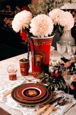 Güzel bir tabak ve mükemmel renkte çiçekler lüks bir masada duruyor.