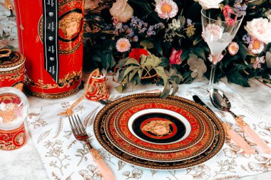 Güzel bir tabak ve mükemmel renkte çiçekler lüks bir masada duruyor.