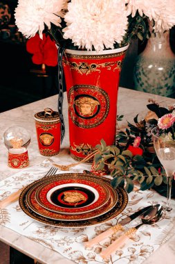 Güzel bir tabak ve mükemmel renkte çiçekler lüks bir masada duruyor.