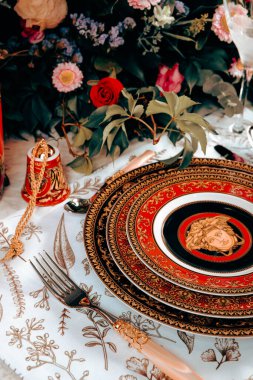 Güzel bir tabak ve mükemmel renkte çiçekler lüks bir masada duruyor.