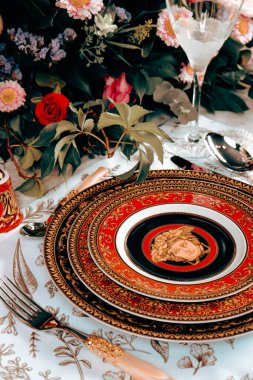 Güzel bir tabak ve mükemmel renkte çiçekler lüks bir masada duruyor.