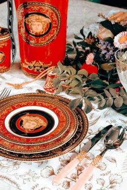 Güzel bir tabak ve mükemmel renkte çiçekler lüks bir masada duruyor.