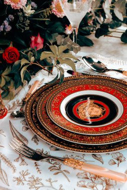 Güzel bir tabak ve mükemmel renkte çiçekler lüks bir masada duruyor.