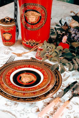 Güzel bir tabak ve mükemmel renkte çiçekler lüks bir masada duruyor.