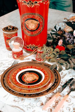 Güzel bir tabak ve mükemmel renkte çiçekler lüks bir masada duruyor.