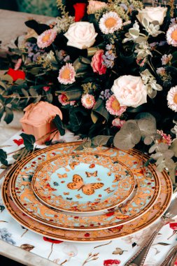 Güzel bir tabak ve mükemmel renkte çiçekler lüks bir masada duruyor.