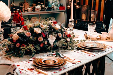 Güzel bir tabak ve mükemmel renkte çiçekler lüks bir masada duruyor.