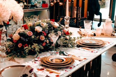 Güzel bir tabak ve mükemmel renkte çiçekler lüks bir masada duruyor.