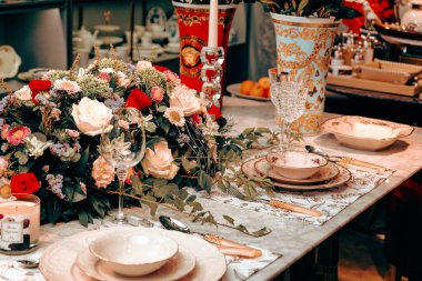 Güzel bir tabak ve mükemmel renkte çiçekler lüks bir masada duruyor.