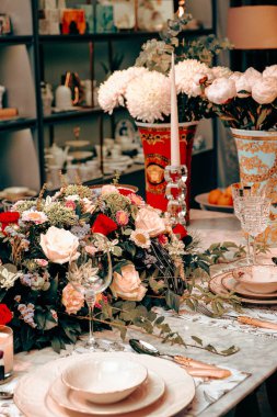 Güzel bir tabak ve mükemmel renkte çiçekler lüks bir masada duruyor.