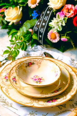 Güzel bir tabak ve mükemmel renkte çiçekler lüks bir masada duruyor.