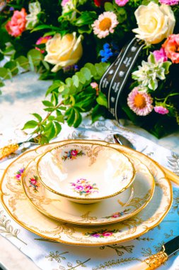 Güzel bir tabak ve mükemmel renkte çiçekler lüks bir masada duruyor.