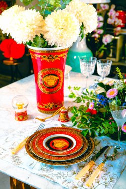 Güzel bir tabak ve mükemmel renkte çiçekler lüks bir masada duruyor.