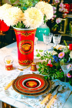 Güzel bir tabak ve mükemmel renkte çiçekler lüks bir masada duruyor.