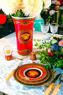 Güzel bir tabak ve mükemmel renkte çiçekler lüks bir masada duruyor.