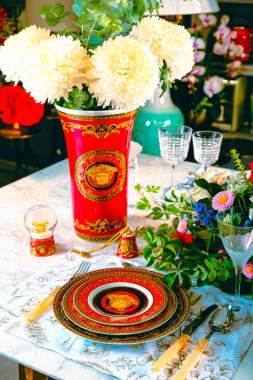 Güzel bir tabak ve mükemmel renkte çiçekler lüks bir masada duruyor.