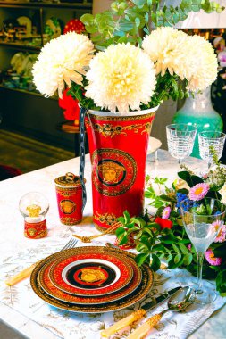 Güzel bir tabak ve mükemmel renkte çiçekler lüks bir masada duruyor.