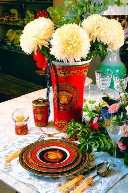 Güzel bir tabak ve mükemmel renkte çiçekler lüks bir masada duruyor.