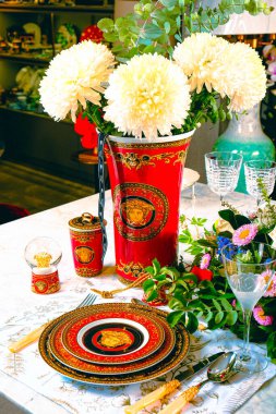 Güzel bir tabak ve mükemmel renkte çiçekler lüks bir masada duruyor.