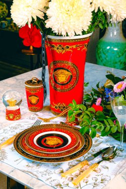 Güzel bir tabak ve mükemmel renkte çiçekler lüks bir masada duruyor.