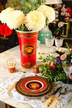 Güzel bir tabak ve mükemmel renkte çiçekler lüks bir masada duruyor.