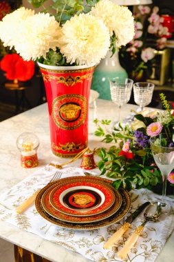 Güzel bir tabak ve mükemmel renkte çiçekler lüks bir masada duruyor.