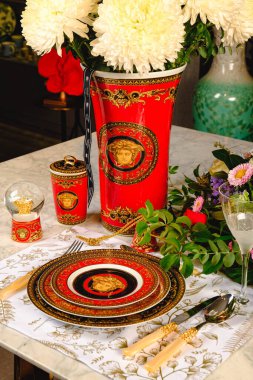 Güzel bir tabak ve mükemmel renkte çiçekler lüks bir masada duruyor.