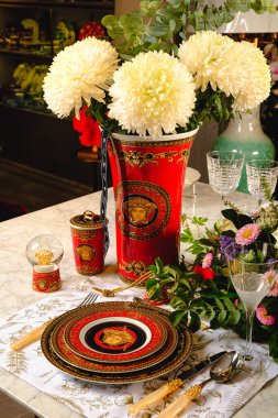 Güzel bir tabak ve mükemmel renkte çiçekler lüks bir masada duruyor.