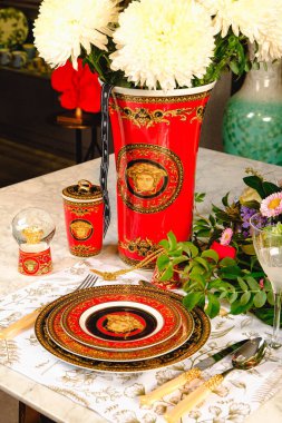 Güzel bir tabak ve mükemmel renkte çiçekler lüks bir masada duruyor.