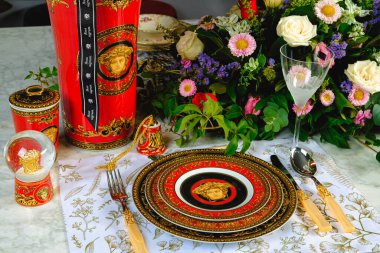 Güzel bir tabak ve mükemmel renkte çiçekler lüks bir masada duruyor.