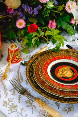 Güzel bir tabak ve mükemmel renkte çiçekler lüks bir masada duruyor.