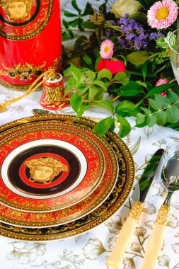 Güzel bir tabak ve mükemmel renkte çiçekler lüks bir masada duruyor.