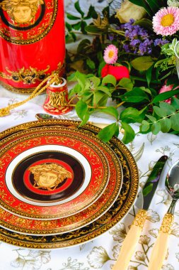 Güzel bir tabak ve mükemmel renkte çiçekler lüks bir masada duruyor.