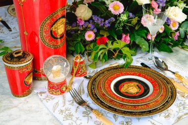 Güzel bir tabak ve mükemmel renkte çiçekler lüks bir masada duruyor.