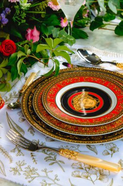 Güzel bir tabak ve mükemmel renkte çiçekler lüks bir masada duruyor.