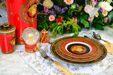 Güzel bir tabak ve mükemmel renkte çiçekler lüks bir masada duruyor.