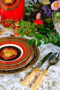 Güzel bir tabak ve mükemmel renkte çiçekler lüks bir masada duruyor.