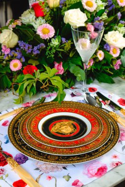 Güzel bir tabak ve mükemmel renkte çiçekler lüks bir masada duruyor.