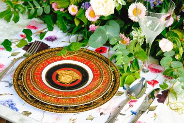 Güzel bir tabak ve mükemmel renkte çiçekler lüks bir masada duruyor.