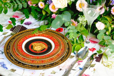 Güzel bir tabak ve mükemmel renkte çiçekler lüks bir masada duruyor.