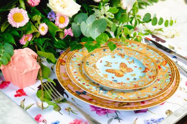 Güzel bir tabak ve mükemmel renkte çiçekler lüks bir masada duruyor.