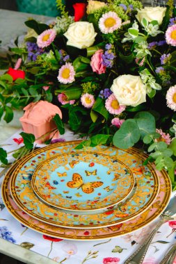 Güzel bir tabak ve mükemmel renkte çiçekler lüks bir masada duruyor.
