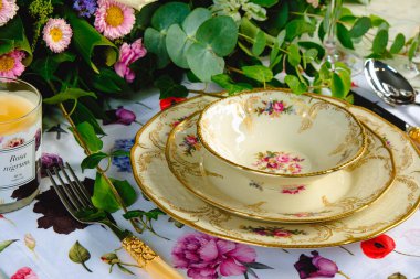 Güzel bir tabak ve mükemmel renkte çiçekler lüks bir masada duruyor.