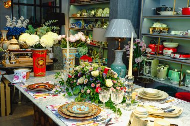 Güzel bir tabak ve mükemmel renkte çiçekler lüks bir masada duruyor.