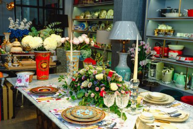 Güzel bir tabak ve mükemmel renkte çiçekler lüks bir masada duruyor.