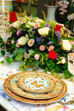 Güzel bir tabak ve mükemmel renkte çiçekler lüks bir masada duruyor.