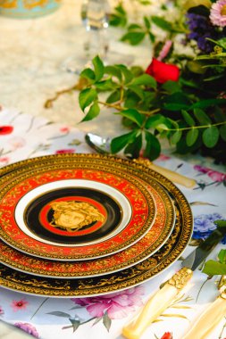 Güzel bir tabak ve mükemmel renkte çiçekler lüks bir masada duruyor.